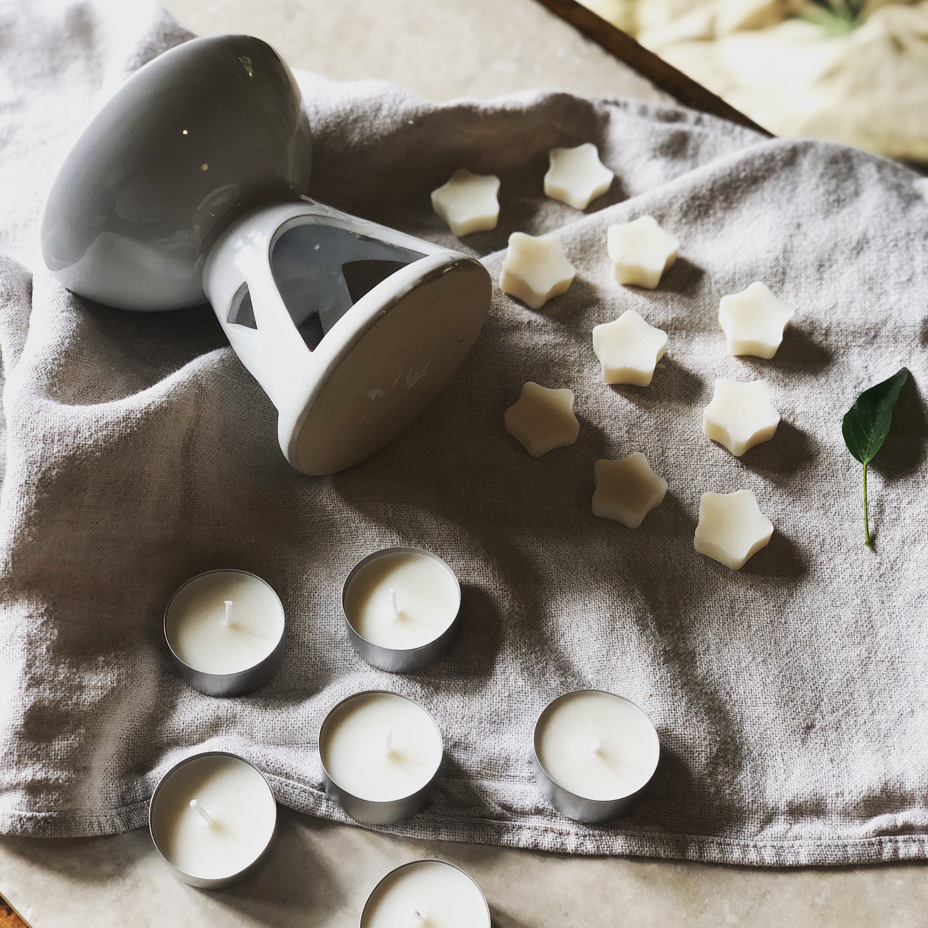 white ceramic oil burner with soy wax melts and tea lights side view