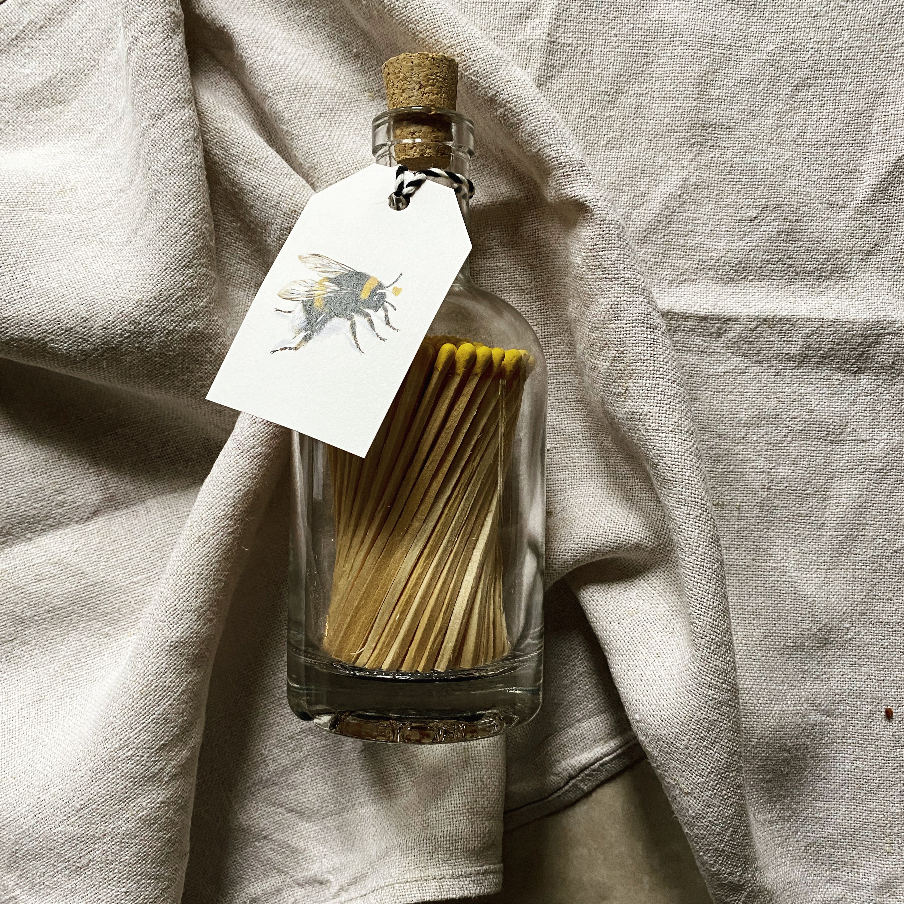 bee label match bottle with yellow tipped matches