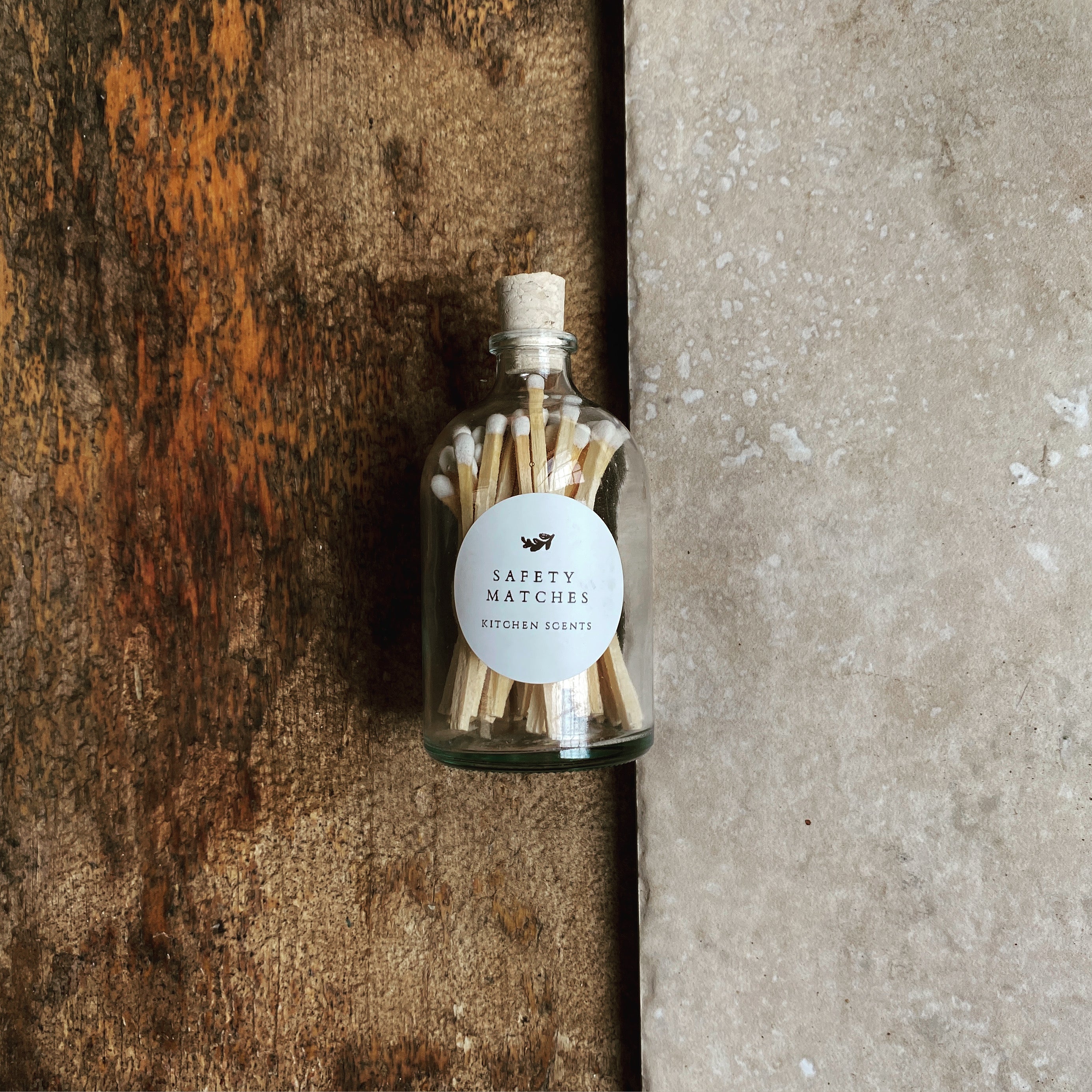 small bottle with cork and white tipped matches