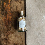 small bottle with cork and white tipped matches